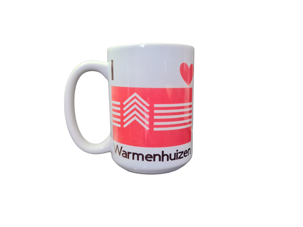 Grote mok (425 ml) met de vlag van Warmenhuizen en de tekst I Love Warmenhuizen met op de achterkant een foto van een plek in dit dorp. Op foto een mok met bedrukking voor linkshandigen